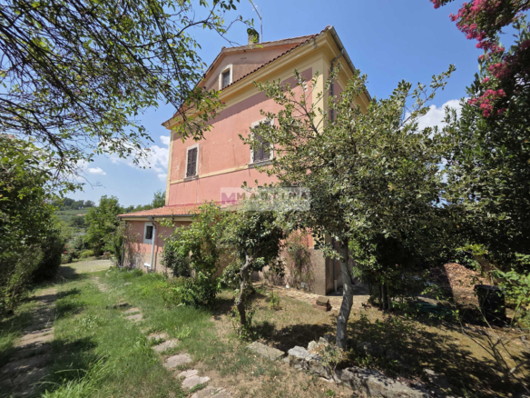 Portion of a three-storey farmhouse with garden