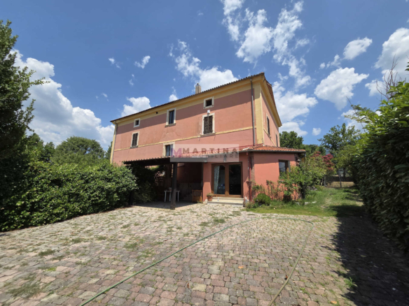 Portion of a three-storey farmhouse with garden